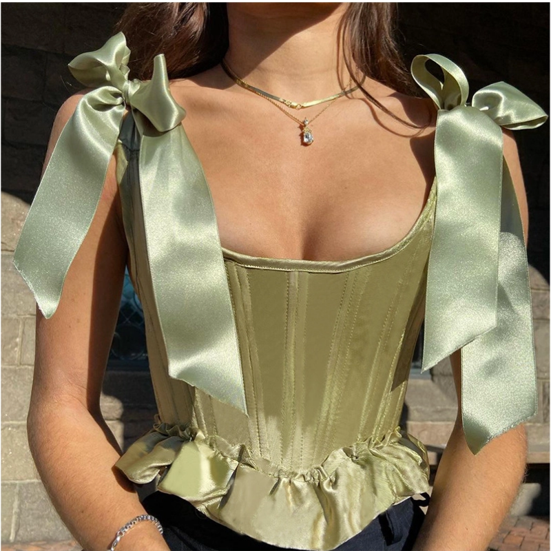 une femme qui porte un corset bustier vintage de couleur verte